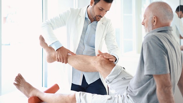 A doctor examining a patient's leg in Louisville, KY